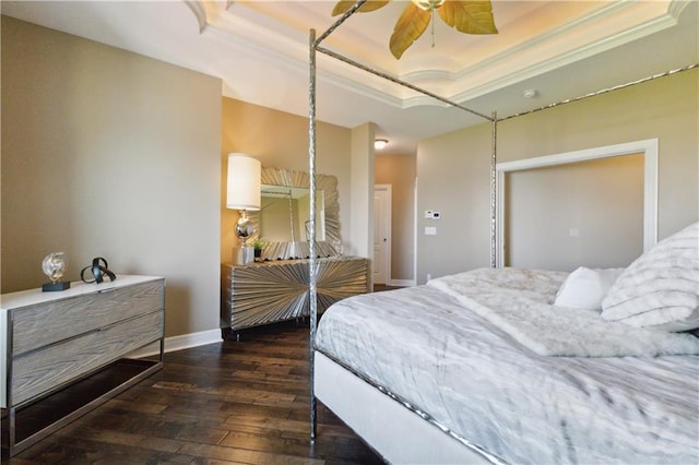 bedroom with crown molding, baseboards, a tray ceiling, and dark wood finished floors