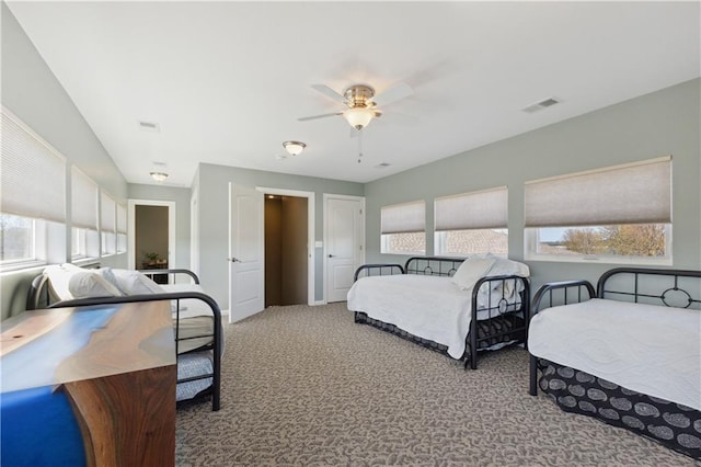bedroom featuring a ceiling fan, visible vents, and carpet