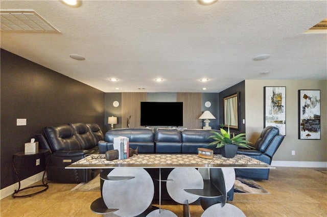 living room featuring visible vents, baseboards, recessed lighting, and a textured ceiling