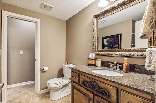 bathroom with visible vents, toilet, vanity, and tile patterned floors