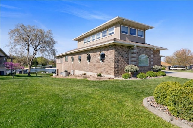 view of side of home featuring a lawn, brick siding, and stucco siding