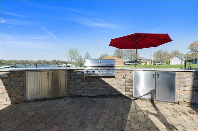 view of patio with an outdoor kitchen, a sink, and area for grilling