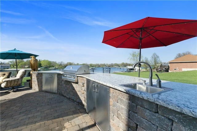 view of patio featuring area for grilling, a sink, and a grill