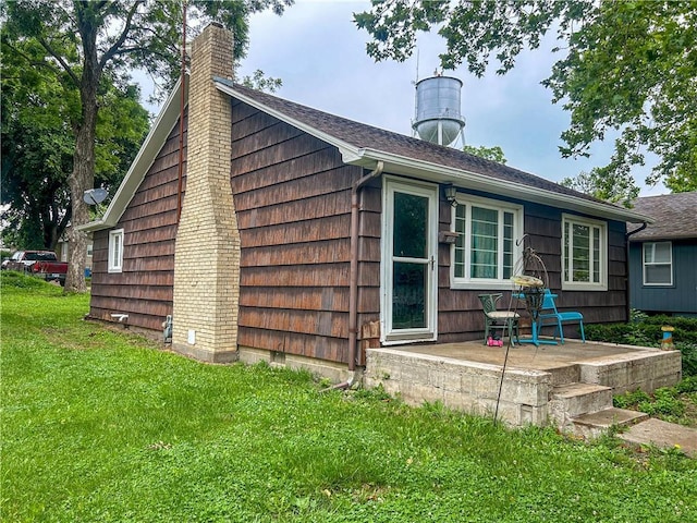 1124 Pacific Ave, Osawatomie, KS 66064 - view of property exterior with a lawn and a chimney