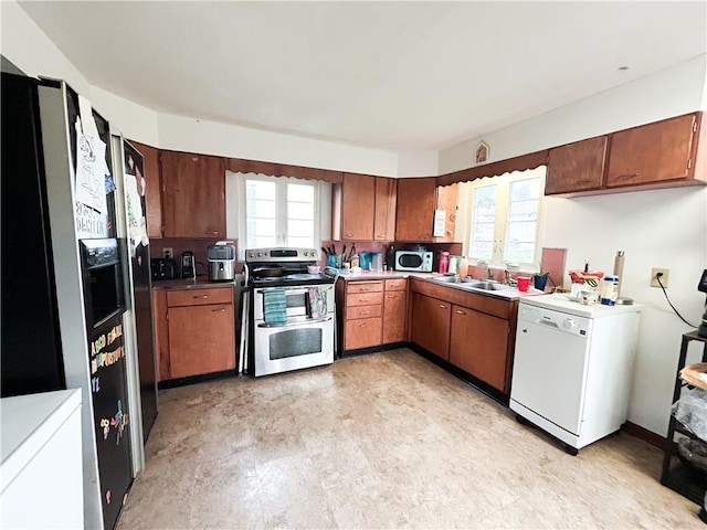 1124 Pacific Ave, Osawatomie, KS 66064 - kitchen with stainless steel appliances, light floors, and brown cabinetry