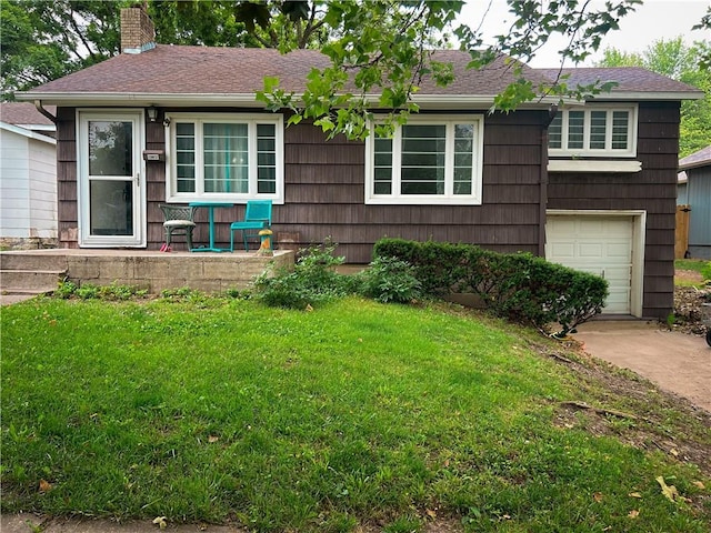 1124 Pacific Ave, Osawatomie, KS 66064 - view of front of home featuring a front yard, a garage, a chimney, and concrete driveway