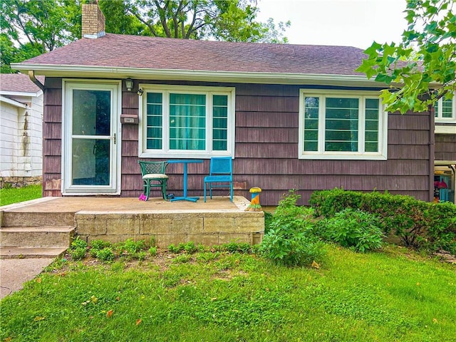 1124 Pacific Ave, Osawatomie, KS 66064 - view of front of home featuring a chimney, roof with shingles, a front yard, and covered porch
