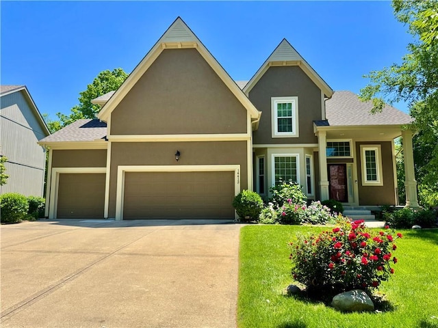 14413 Stearns St, Overland Park, KS 66211 - view of front of house featuring an attached garage, a front yard, driveway, and stucco siding