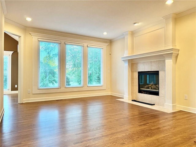 14413 Stearns St, Overland Park, KS 66211 - unfurnished living room with crown molding, wood finished floors, a tiled fireplace, baseboards, and recessed lighting