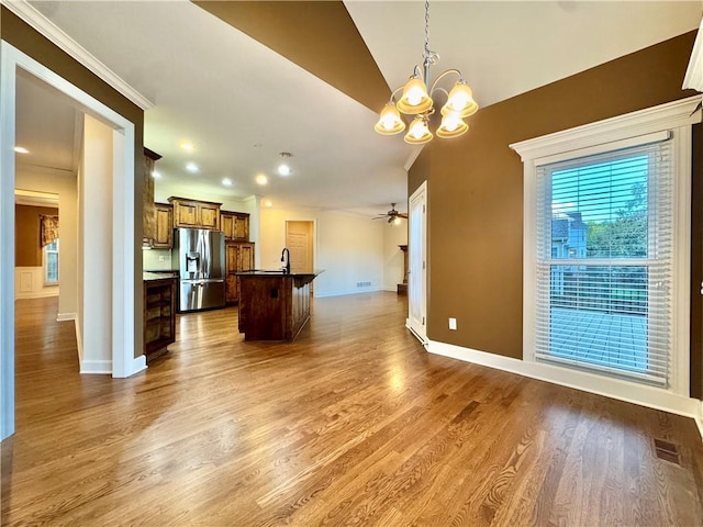 14413 Stearns St, Overland Park, KS 66211 - kitchen with stainless steel refrigerator with ice dispenser, open floor plan, a chandelier, a center island with sink, and baseboards