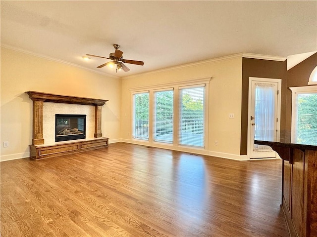 14413 Stearns St, Overland Park, KS 66211 - unfurnished living room featuring wood finished floors, crown molding, baseboards, a ceiling fan, and a premium fireplace