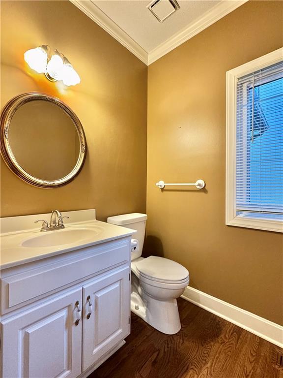 14413 Stearns St, Overland Park, KS 66211 - half bath with ornamental molding, wood finished floors, vanity, toilet, and baseboards