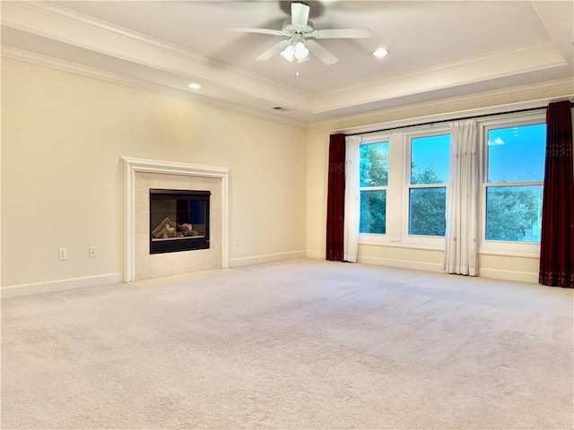 14413 Stearns St, Overland Park, KS 66211 - unfurnished living room with crown molding, a tray ceiling, ceiling fan, light carpet, and a tile fireplace