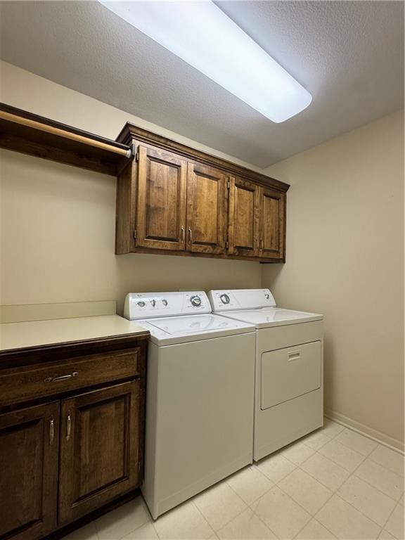 14413 Stearns St, Overland Park, KS 66211 - laundry room with cabinet space, independent washer and dryer, baseboards, and a textured ceiling