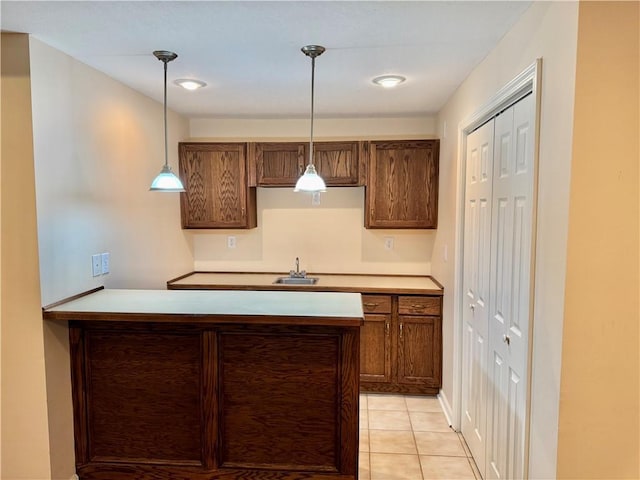 14413 Stearns St, Overland Park, KS 66211 - kitchen featuring a sink, hanging light fixtures, a peninsula, light tile patterned floors, and light countertops