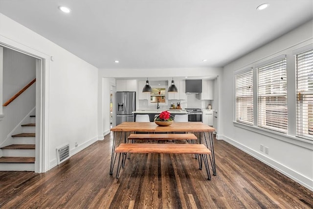 5933 Rockhill Rd, Kansas City, MO 64110 - dining area with dark wood-type flooring, stairway, recessed lighting, and baseboards