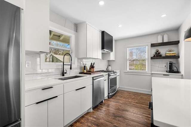 5933 Rockhill Rd, Kansas City, MO 64110 - kitchen with stainless steel appliances, light countertops, a sink, backsplash, and dark wood-style flooring