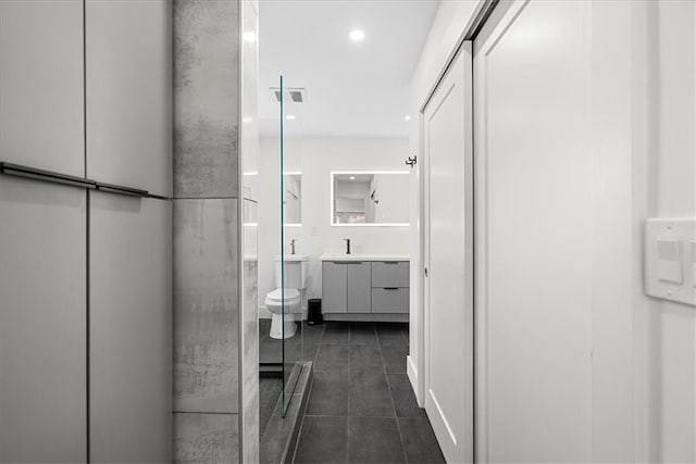 5933 Rockhill Rd, Kansas City, MO 64110 - bathroom featuring toilet, vanity, recessed lighting, and tile patterned flooring