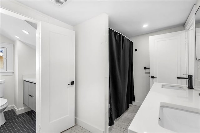 5933 Rockhill Rd, Kansas City, MO 64110 - bathroom featuring toilet, double vanity, baseboards, recessed lighting, and a shower with shower curtain