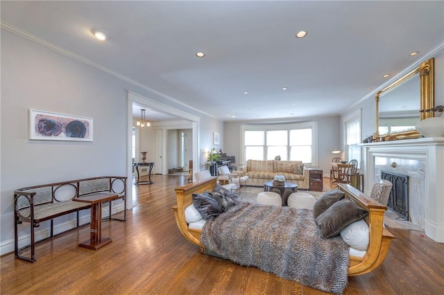living area featuring ornamental molding, a fireplace, recessed lighting, and wood finished floors
