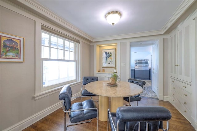 dining area with baseboards, ornamental molding, and wood finished floors