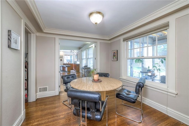 dining area featuring visible vents, crown molding, and wood finished floors