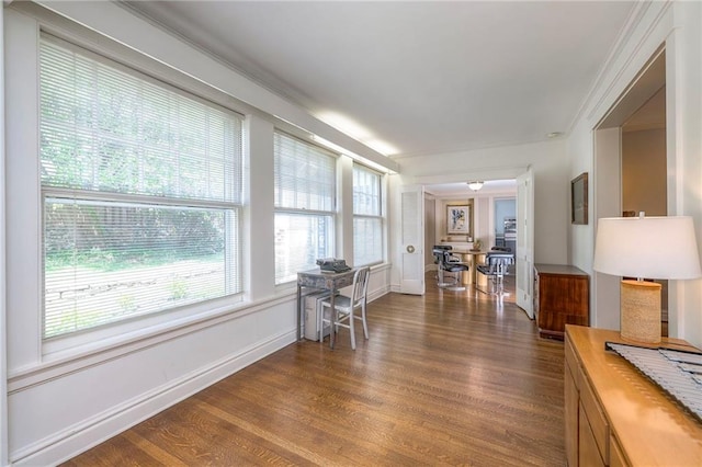 interior space featuring dark wood-style flooring, baseboards, and ornamental molding