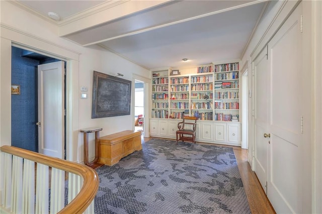 living area featuring built in shelves, ornamental molding, and wood finished floors