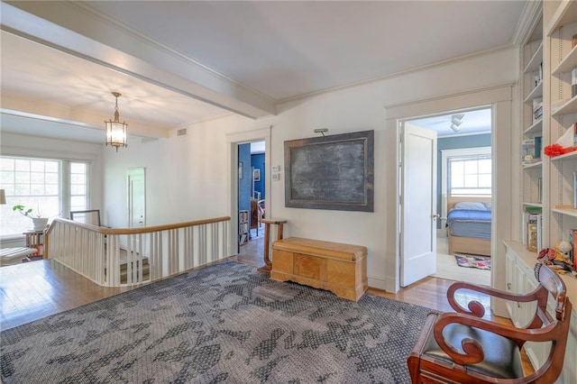 sitting room featuring crown molding, an upstairs landing, and wood finished floors