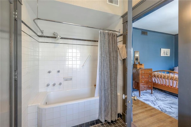 ensuite bathroom featuring connected bathroom, tiled shower / bath, and visible vents
