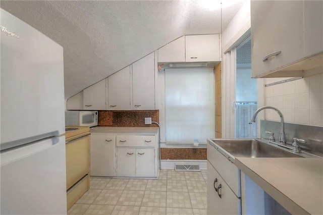 kitchen featuring a sink, white cabinetry, white appliances, and tasteful backsplash
