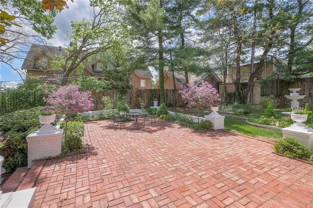 view of property's community with a fenced backyard, a patio, and outdoor dining area