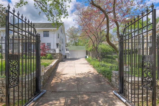 view of property exterior featuring a gate, stucco siding, fence, and a detached garage
