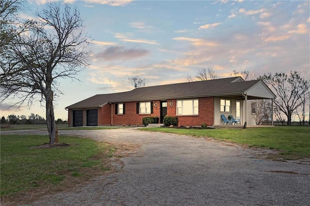 14875 Edgerton Rd, Gardner, KS 66030 - ranch-style house with dirt driveway, a garage, a yard, and brick siding