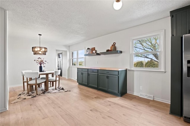 14875 Edgerton Rd, Gardner, KS 66030 - dining space with a textured ceiling, a chandelier, and light wood-style floors