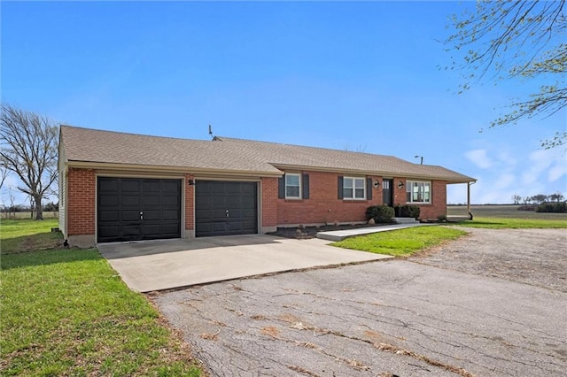 14875 Edgerton Rd, Gardner, KS 66030 - ranch-style home with an attached garage, asphalt driveway, a front lawn, and brick siding