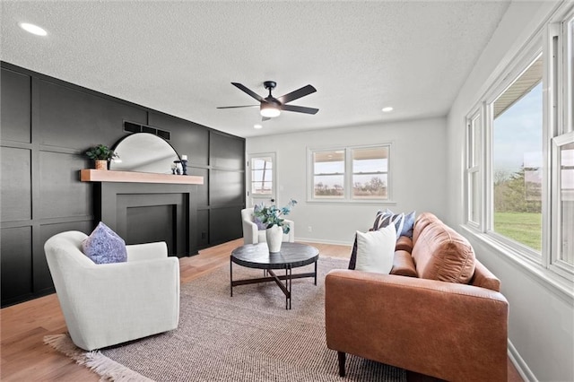 14875 Edgerton Rd, Gardner, KS 66030 - living area with a textured ceiling, light wood-style floors, a fireplace, ceiling fan, and recessed lighting