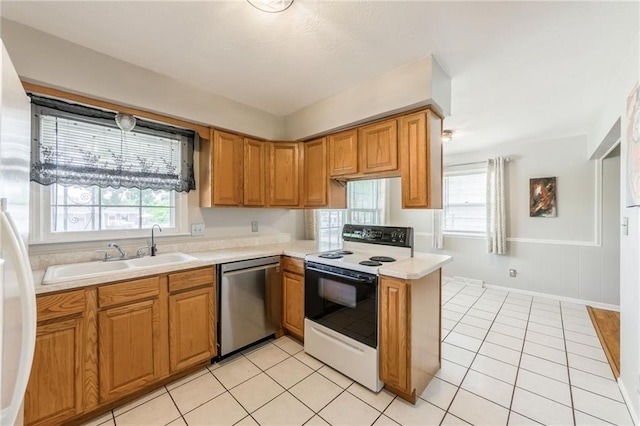 7201 E 130th Ter, Grandview, MO 64030 - kitchen with stainless steel dishwasher, range with electric stovetop, plenty of natural light, light countertops, and a wainscoted wall