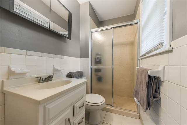 7201 E 130th Ter, Grandview, MO 64030 - bathroom with tile walls, tile patterned floors, a stall shower, vanity, and a wainscoted wall
