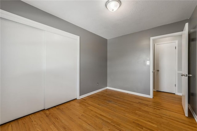 7201 E 130th Ter, Grandview, MO 64030 - unfurnished bedroom with wood finished floors and a closet