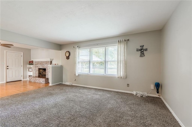 7201 E 130th Ter, Grandview, MO 64030 - unfurnished living room featuring carpet, a brick fireplace, and a ceiling fan