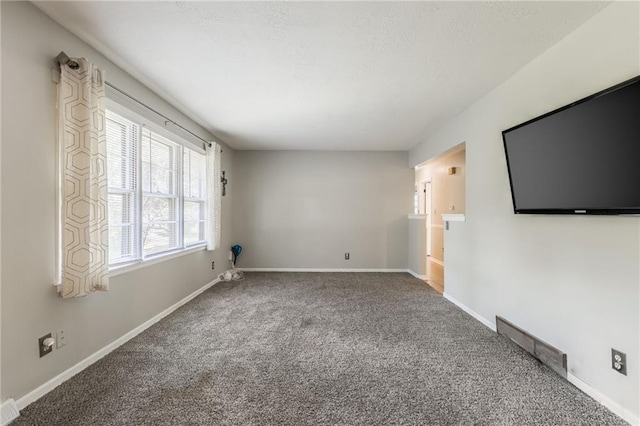 7201 E 130th Ter, Grandview, MO 64030 - unfurnished living room featuring carpet flooring and baseboards