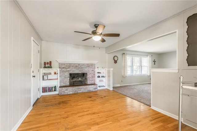 7201 E 130th Ter, Grandview, MO 64030 - unfurnished living room with ceiling fan, light wood finished floors, and a brick fireplace