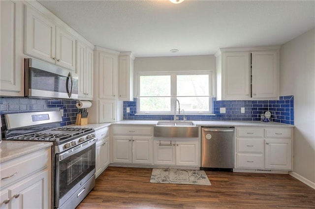 kitchen featuring stainless steel appliances, dark wood-style floors, a sink, and tasteful backsplash