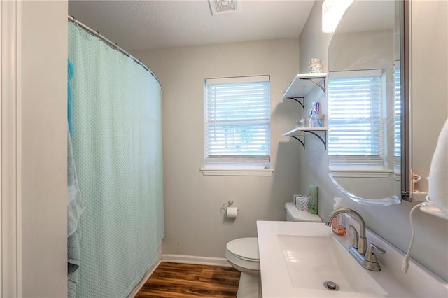 bathroom with visible vents, vanity, wood finished floors, toilet, and baseboards