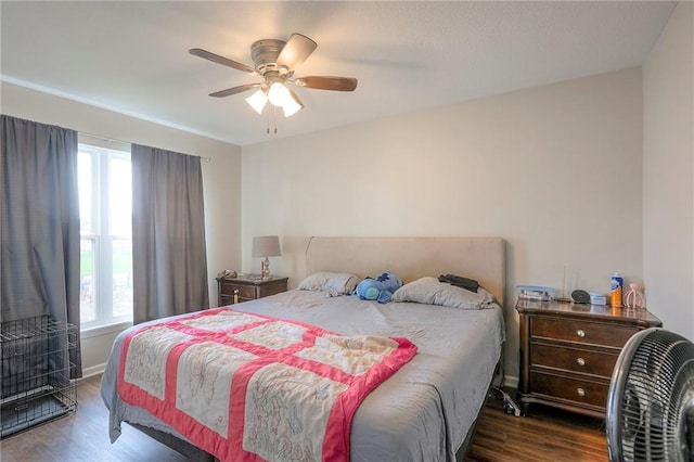 bedroom with baseboards, ceiling fan, multiple windows, and wood finished floors