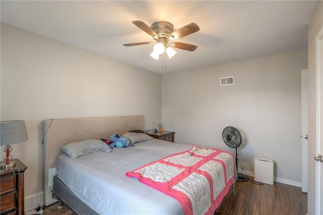 bedroom featuring ceiling fan, baseboards, visible vents, and wood finished floors