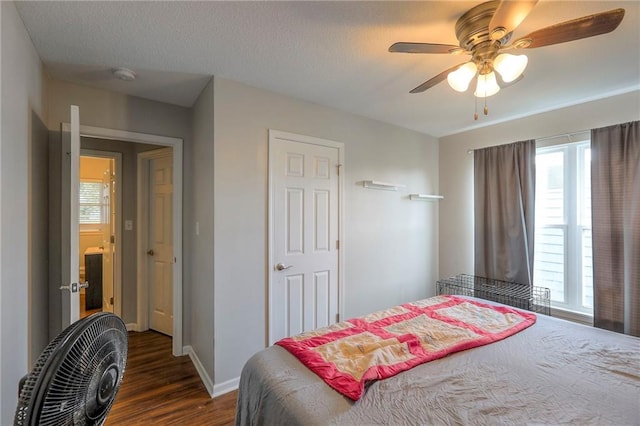 bedroom with baseboards, a ceiling fan, dark wood-style flooring, and multiple windows
