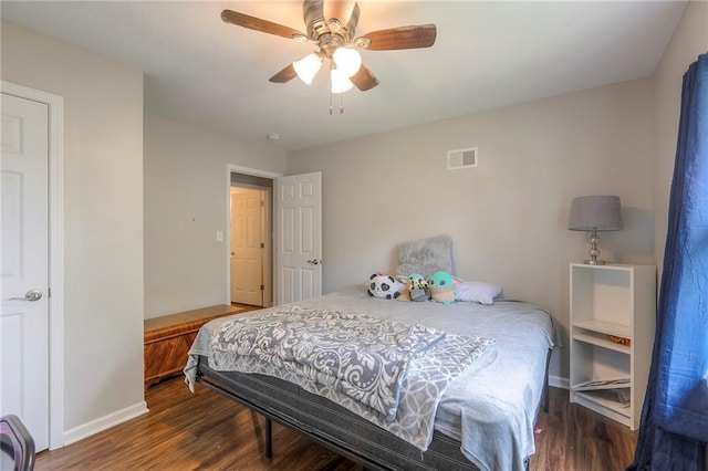 bedroom featuring baseboards, a ceiling fan, wood finished floors, and visible vents