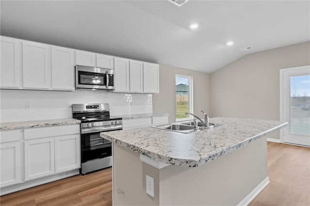 37839 W 207th Ter, Edgerton, KS 66021 - kitchen featuring stainless steel appliances, light wood-type flooring, vaulted ceiling, white cabinetry, and tasteful backsplash